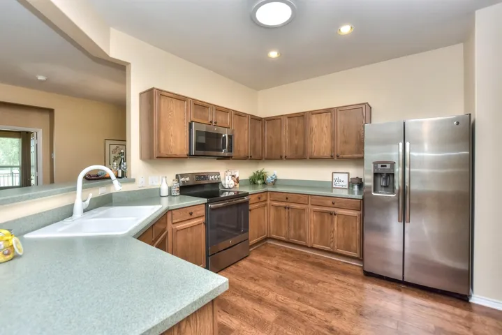 A broader view of the open kitchen...An abundance of cabinets and counter tops, pretty white sinks, and stainless appliances...