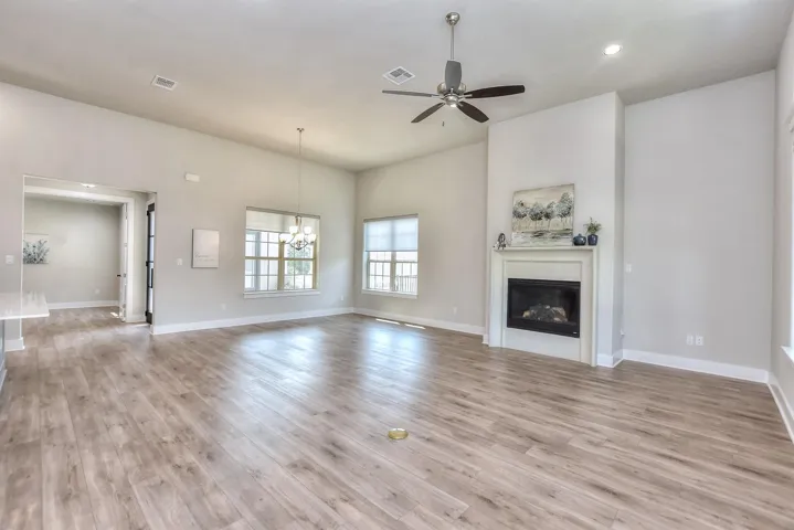 A view from the rear wall of the family room back to the dining area and the front entry to the home...