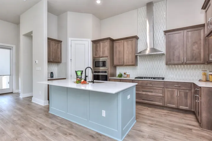 Natural wood cabinets with a painted breakfast bar/center island.  