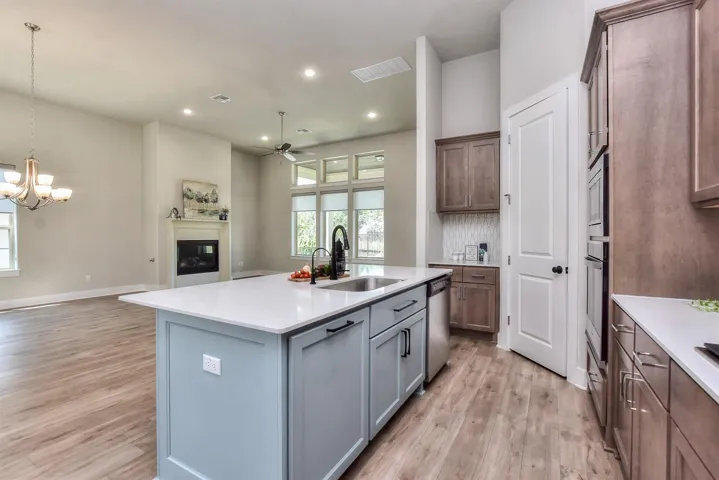 I love the painted center island that pops the kitchen...Farm sink, quartz countertops, gooseneck faucet, & stainless dishwasher....