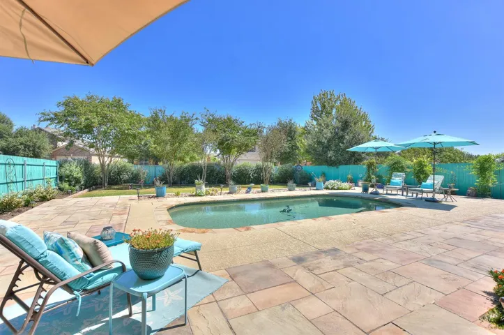 Sparkling in-ground pool with custom stone deck