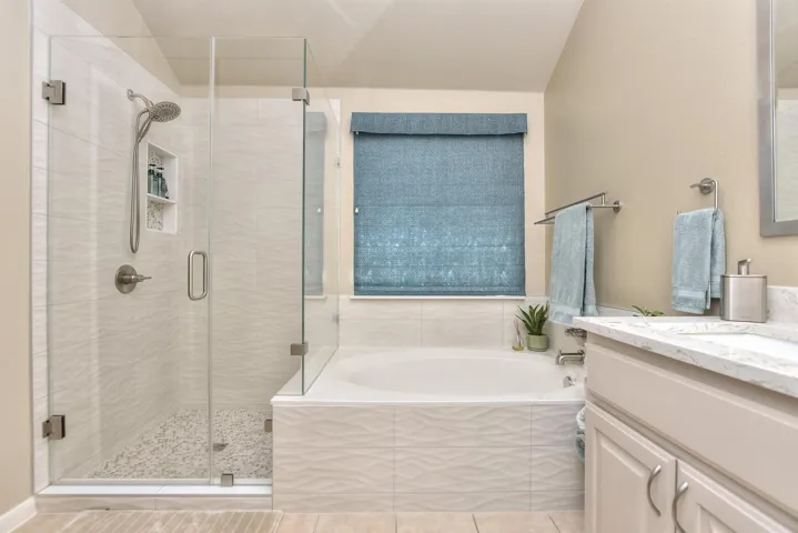 Primary bath with garden soaking tub and separate shower with custom tile work