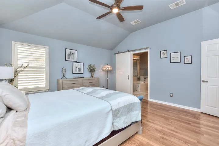 Primary bedroom with sliding barn door leading to en-suite bath