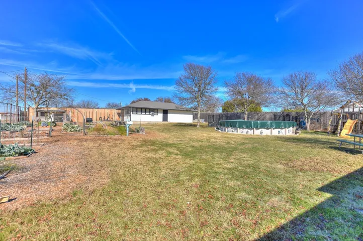 Full view of the backyard;  Garden with irrigation system and Rachio Controller;  Rainbow Play Set in the corner; Chicken Coop in the very back; 842 sq ft Workshop with separate electrical meter