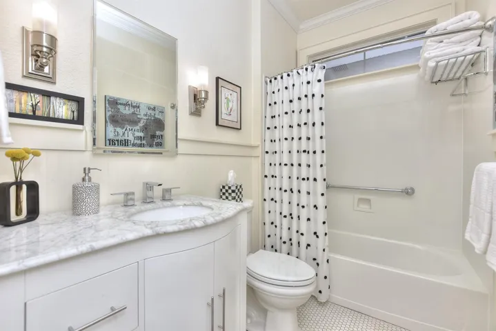Second bathroom is between the family room and the 2nd bedroom.  The cabinet & counterop were also added by the current owners.  Notice the tile floor...