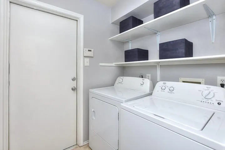 Washroom featuring laundry area and washer and clothes dryer
