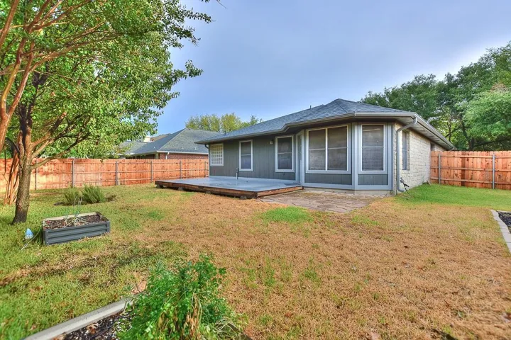 Rear view of property with a patio area, a fenced backyard, and a lawn