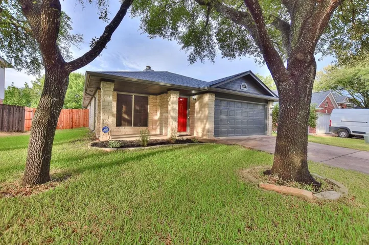 Ranch-style home featuring a garage, a shingled roof, concrete driveway, fence, and a front lawn