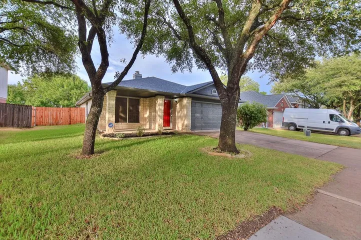 Single story home with driveway, a front lawn, a chimney, and fence