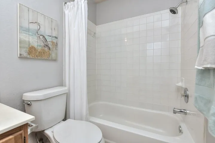 Full bathroom featuring shower / bathtub combination with curtain, vanity, and toilet