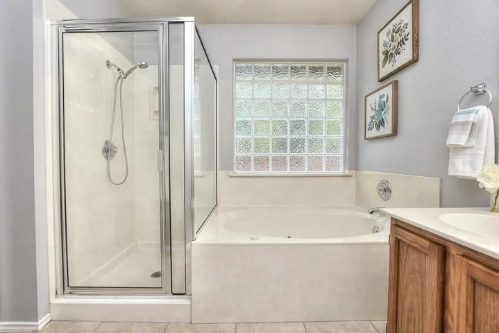 Full bath with a garden tub, vanity, a shower stall, and tile patterned floors