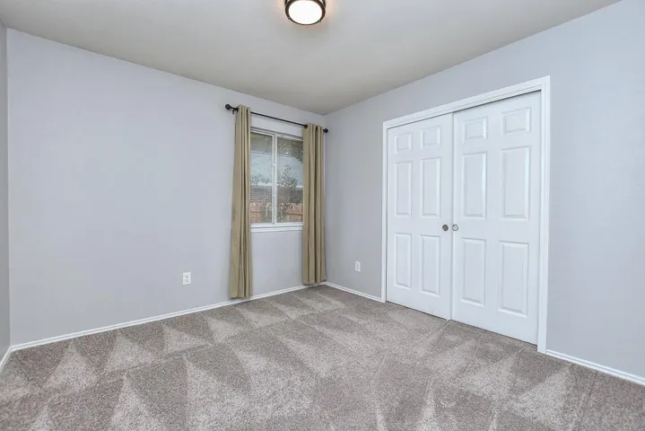 Unfurnished bedroom with light carpet and a closet