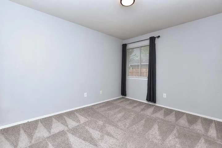 Empty room featuring carpet floors and baseboards