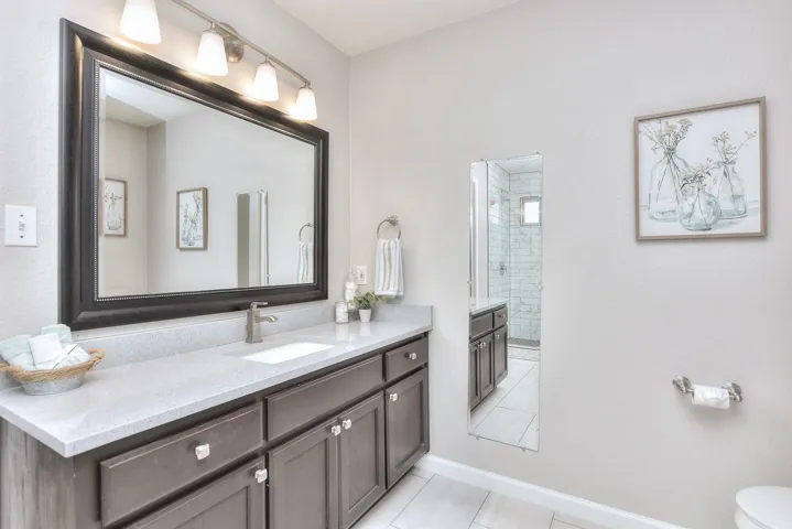 Large extended quartz vanity with updated mirror and lighting