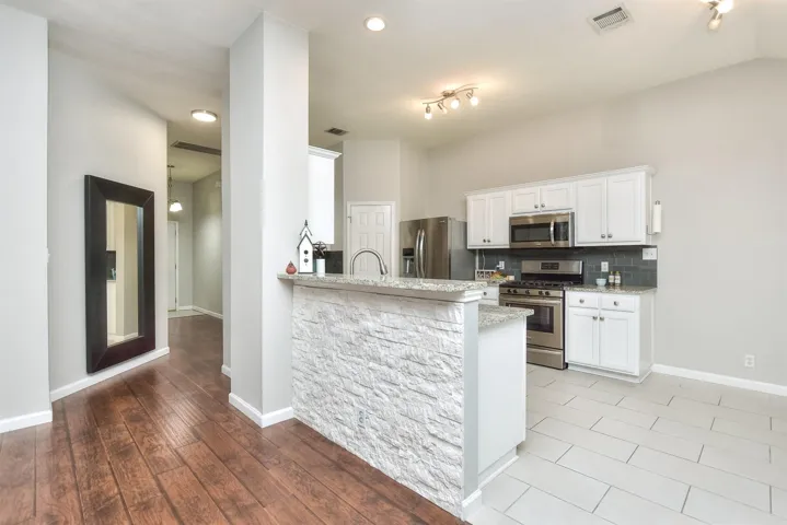 Stone facade at the breakfast bar is the perfect place for a meal or for guests to visit while the host works in the kitchen.