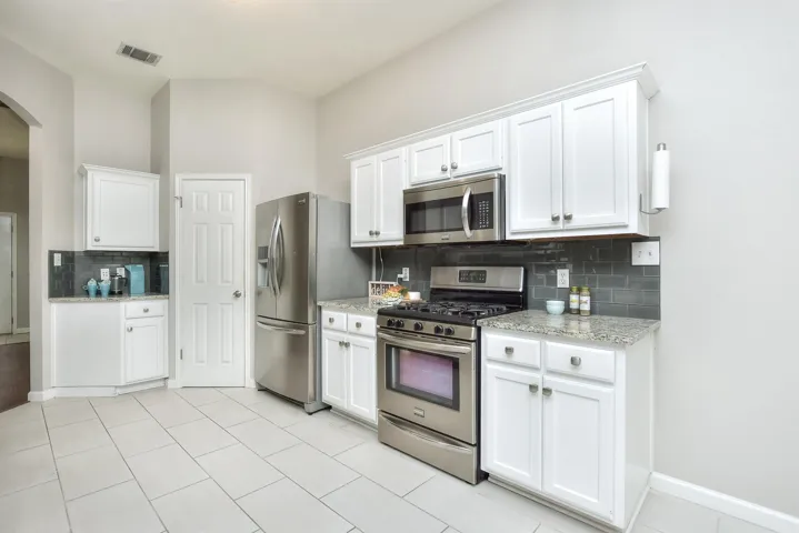 Oversized stylish offset rectangular tile floors and walk-in pantry and the perfect space for a coffee bar! 