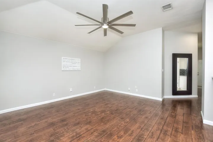 Large, open family room with  wood look laminate flooring.