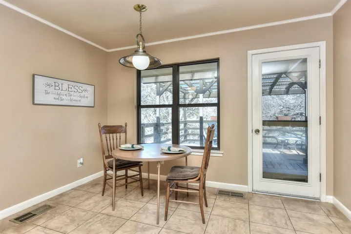 Dining space with crown molding, light tile patterned floors, and visible vents