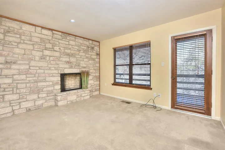 Unfurnished living room featuring visible vents, carpet flooring, baseboards, and a healthy amount of sunlight