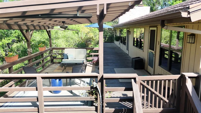 Wooden deck with a pergola and ceiling fan