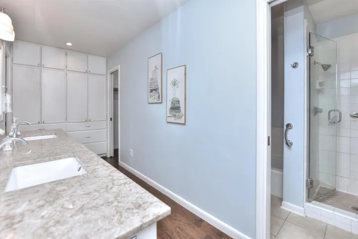 Full bath featuring baseboards, a stall shower, and a sink