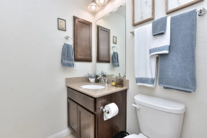 Half bathroom with baseboards, toilet, and vanity