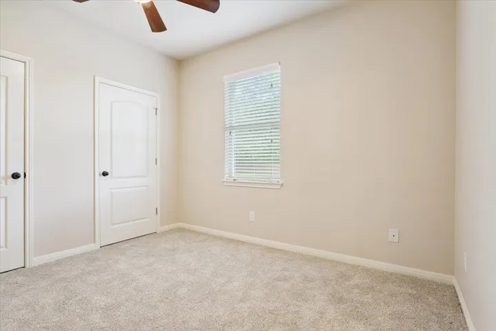 Unfurnished bedroom featuring carpet flooring and ceiling fan