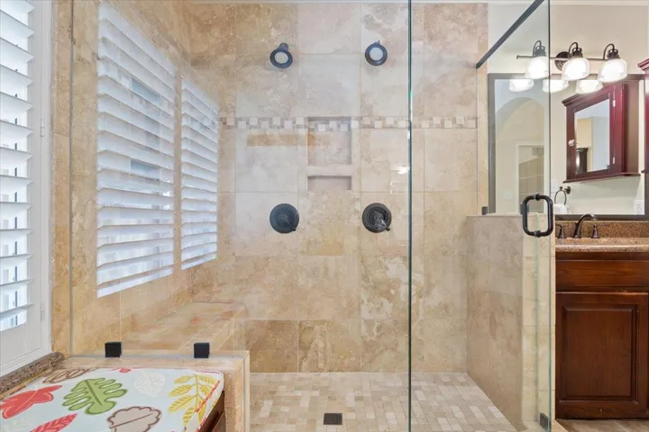 Full bath with a tile shower and vanity