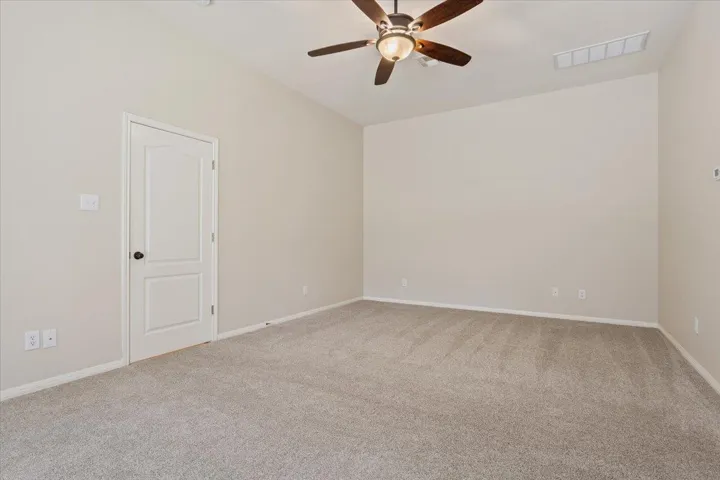 Unfurnished room with ceiling fan and carpet floors