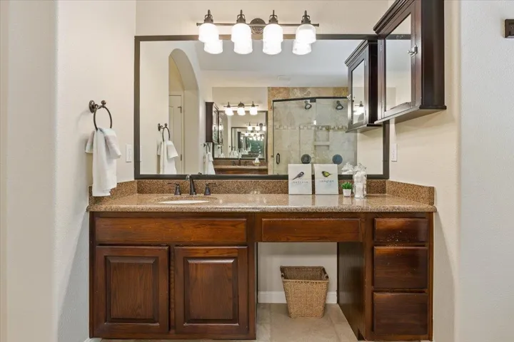 Bathroom featuring a shower stall, vanity, and tile patterned flooring