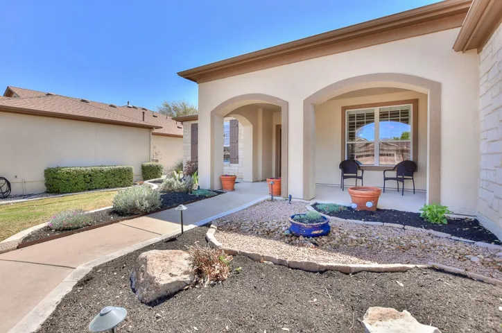 Property entrance with stucco siding and covered porch