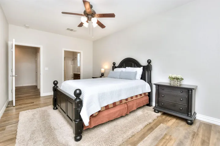 Bedroom with baseboards, light wood finished floors, and visible vents