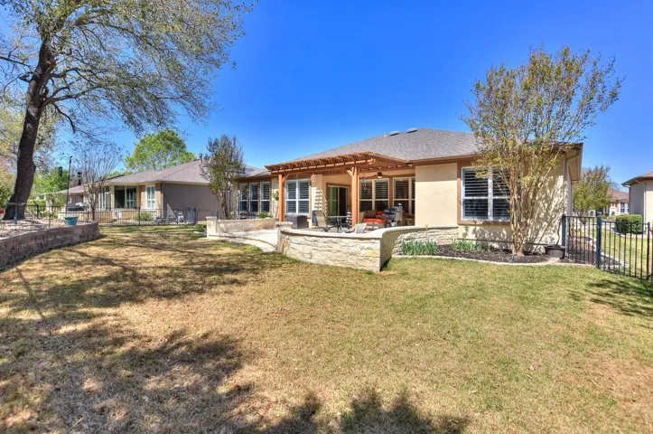 Back of house with a pergola, stucco siding, fence, and a patio