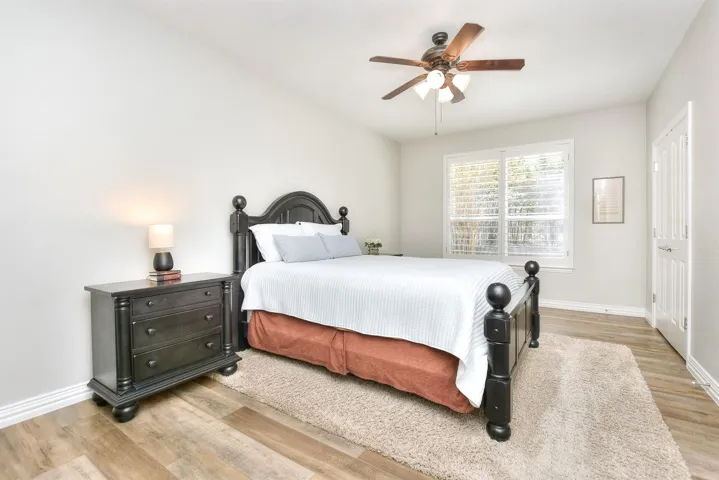 Bedroom with baseboards, light wood-type flooring, and a ceiling fan