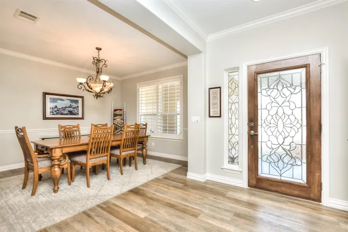Dining space featuring plenty of natural light, visible vents, wood finished floors, and a chandelier