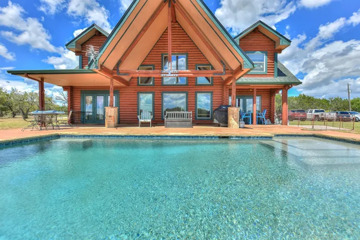 Pool with fence, french doors, and a patio area