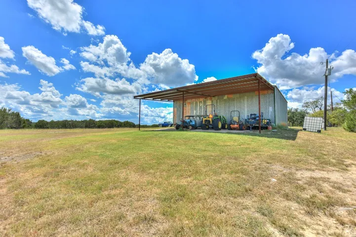 View of pole building with a yard