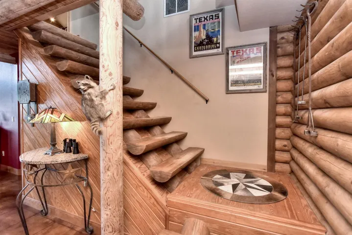 Staircase featuring log walls, baseboards, and visible vents