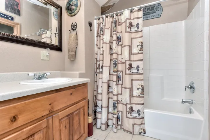 Bathroom with tile patterned flooring, vanity, and shower / bath combo