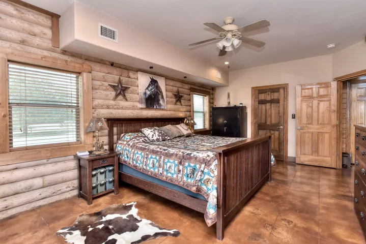 Bedroom with log walls and visible vents