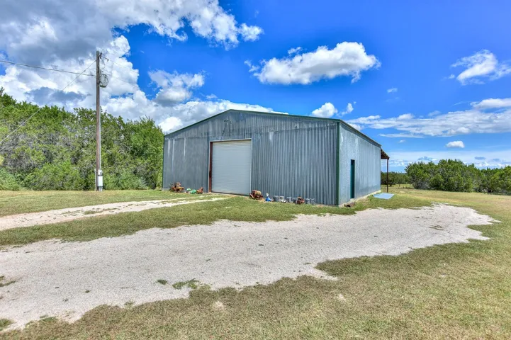 View of outbuilding featuring driveway and an outdoor structure