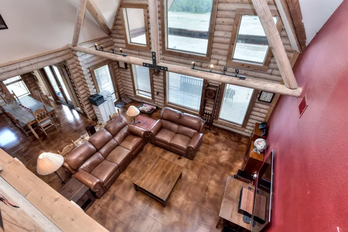 Living area featuring a textured wall and high vaulted ceiling