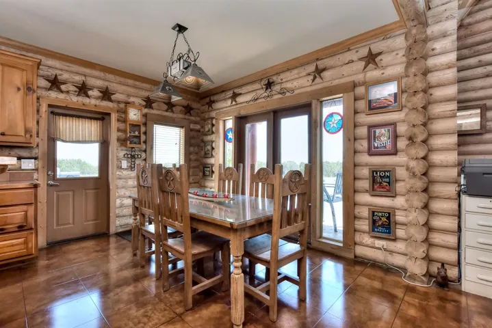 Dining space featuring rustic walls and dark tile patterned flooring