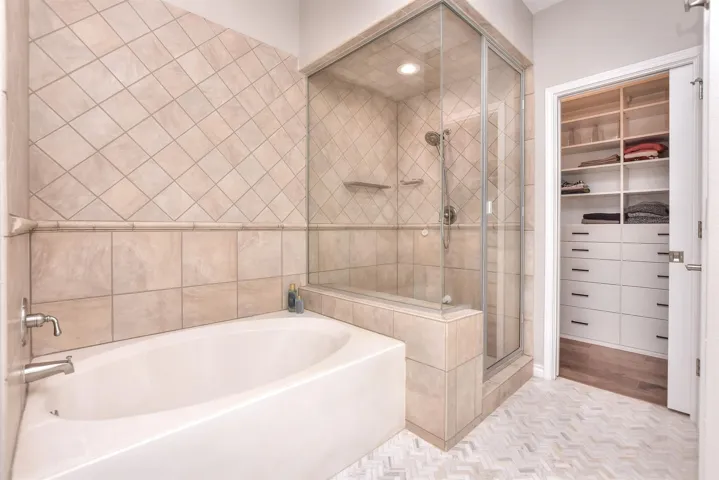Bathroom featuring  a bath tub, a walk-in steam shower and California custom closet
