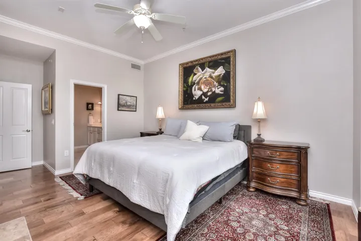 Bedroom with crown molding, connected bathroom