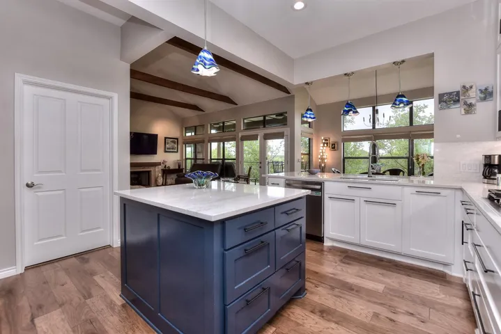 Kitchen featuring white cabinets, a sink, stainless steel dishwasher, beamed ceiling, and blue cabinets