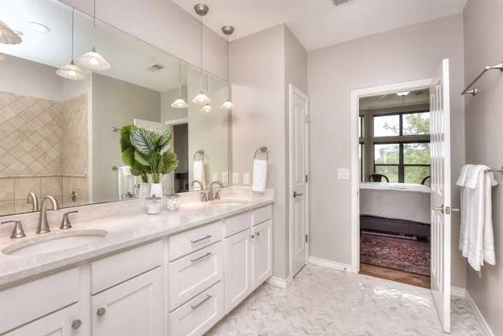 Ensuite bathroom featuring visible vents, a sink,