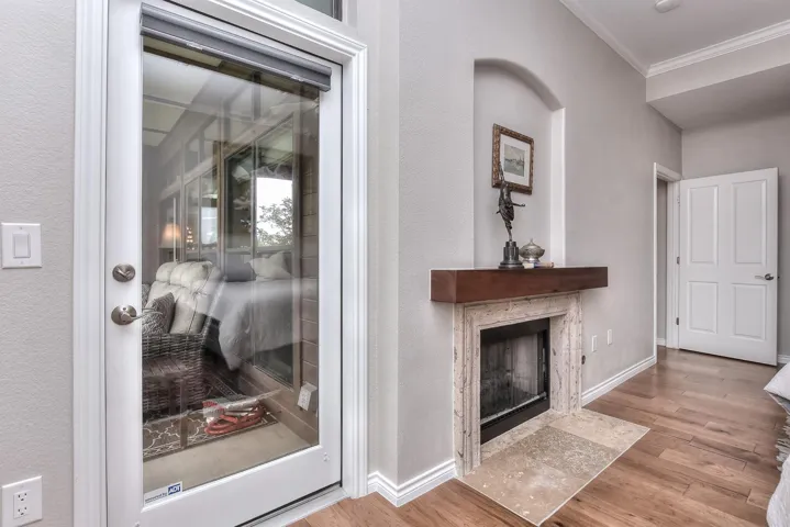 Fireplace and a door to the balcony in the primary bedroom 