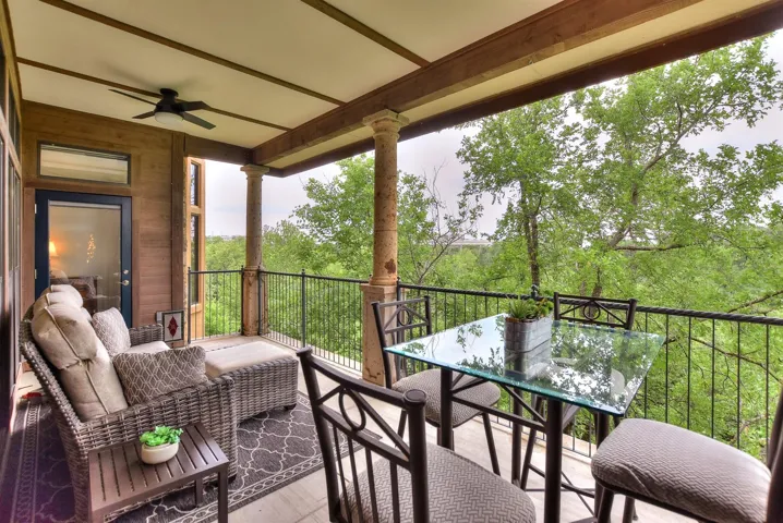 Balcony with outdoor seating and dining area with ceiling fans