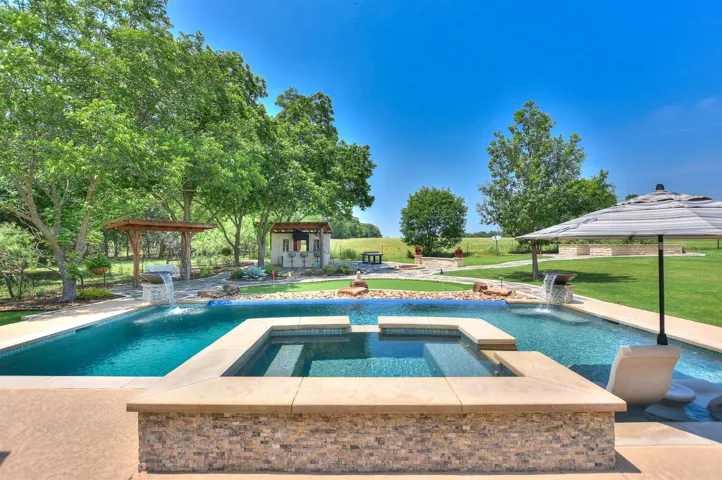 View of swimming pool with a gazebo, a yard, and a pool with connected hot tub